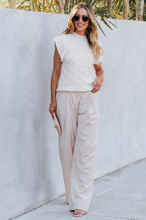 a woman wearing a white sweater and pants