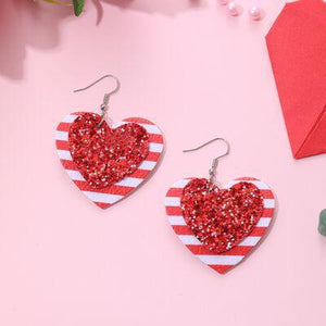 a pair of red and white heart shaped earrings