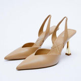 a pair of beige high heeled shoes on a white background