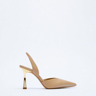 a pair of beige high heeled shoes on a white background