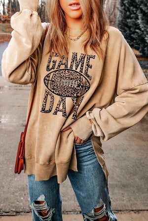 a woman wearing a sweater with a football on it