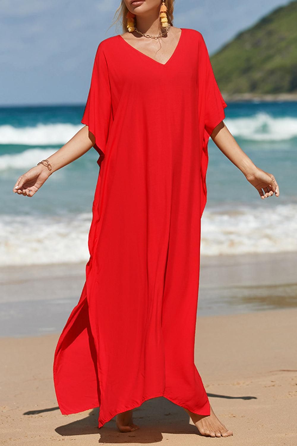 a woman in a red dress standing on a beach