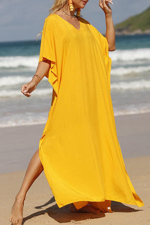 a woman in a yellow dress on the beach