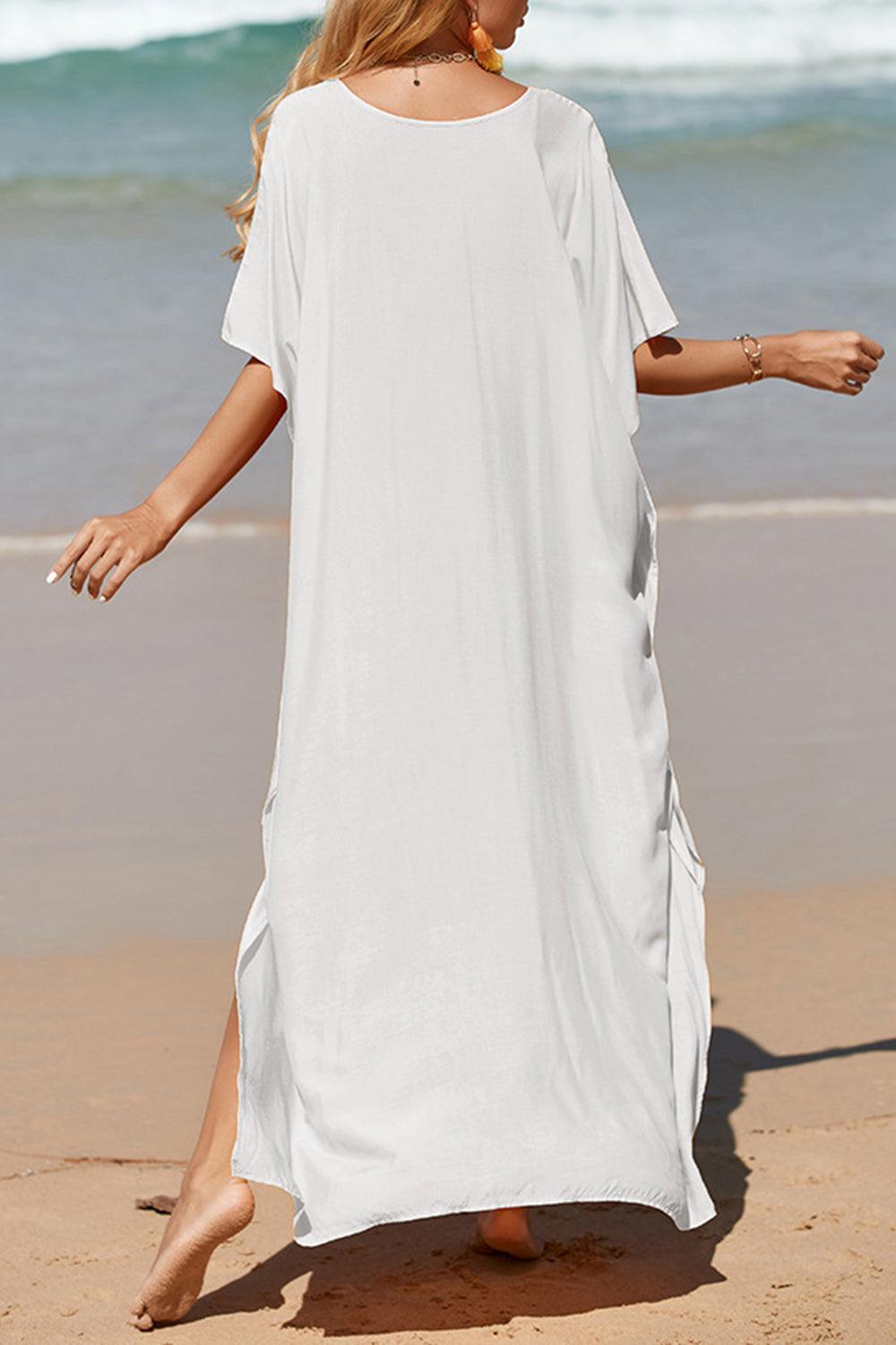 a woman in a white dress walking on the beach