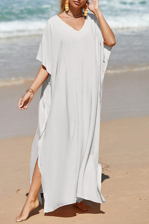 a woman in a white dress walking on the beach