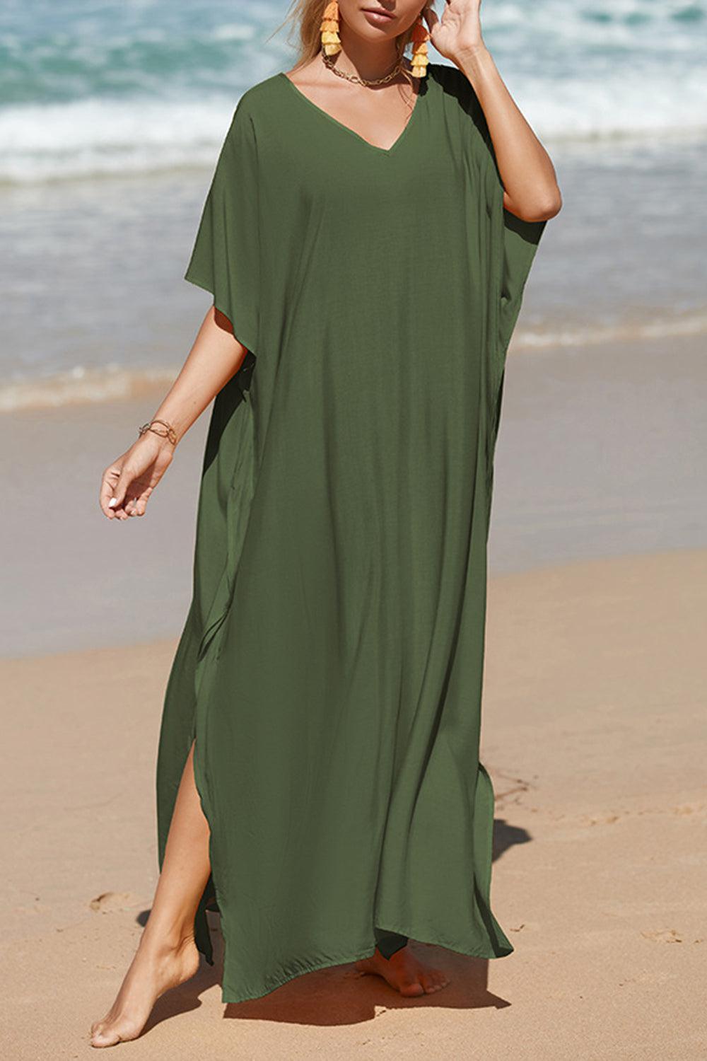 a woman in a green dress walking on the beach