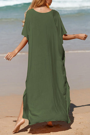 a woman in a green dress walking on the beach