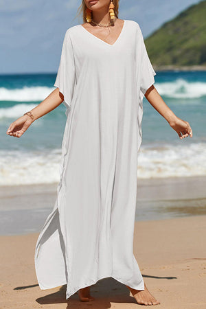 a woman in a white dress standing on a beach