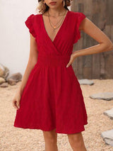 a woman in a red dress posing for a picture