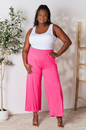 a woman in a white tank top and pink pants