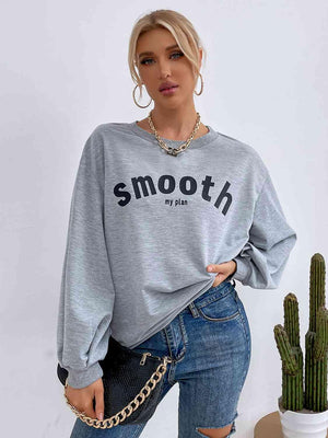 a woman wearing a gray sweatshirt and ripped jeans