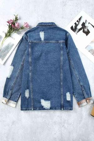 a blue jean jacket with holes on the back