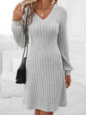 a woman wearing a gray sweater dress