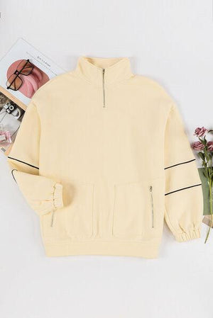 a yellow sweatshirt with a magazine and flowers