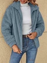 a woman wearing a blue jacket and jeans