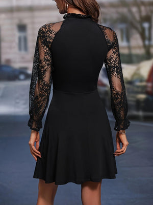 a woman in a black dress is standing on the street