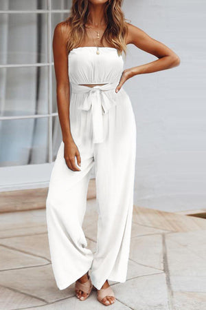 a woman wearing a white strapless jumpsuit