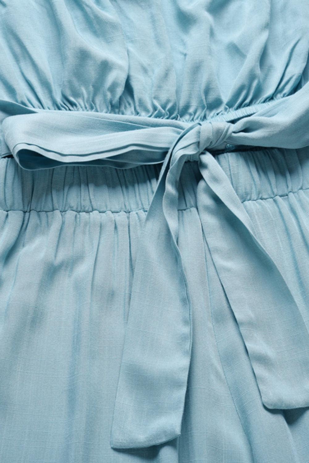 a close up of a blue dress with a tie