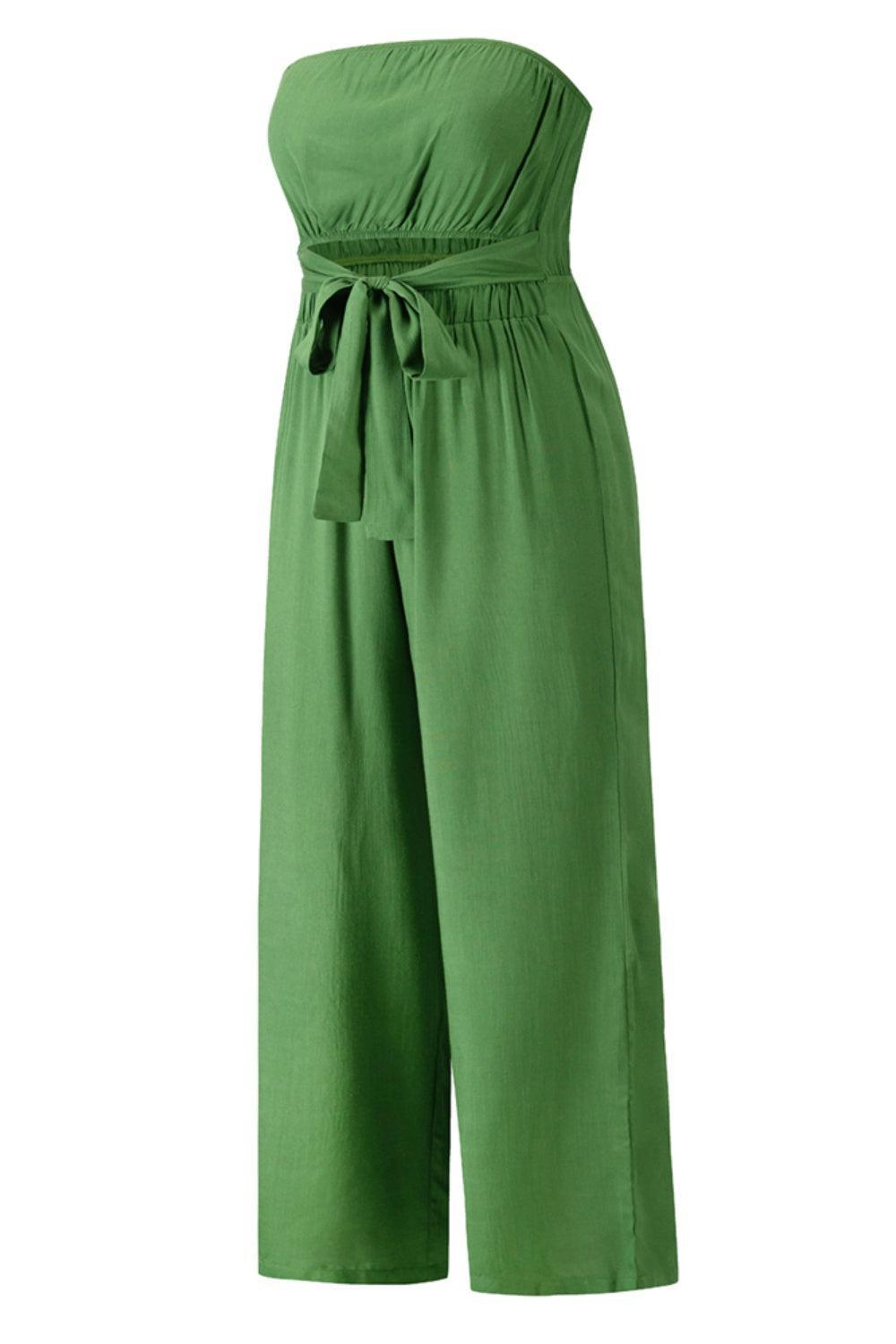 a woman wearing a green jumpsuit with a tie around the waist