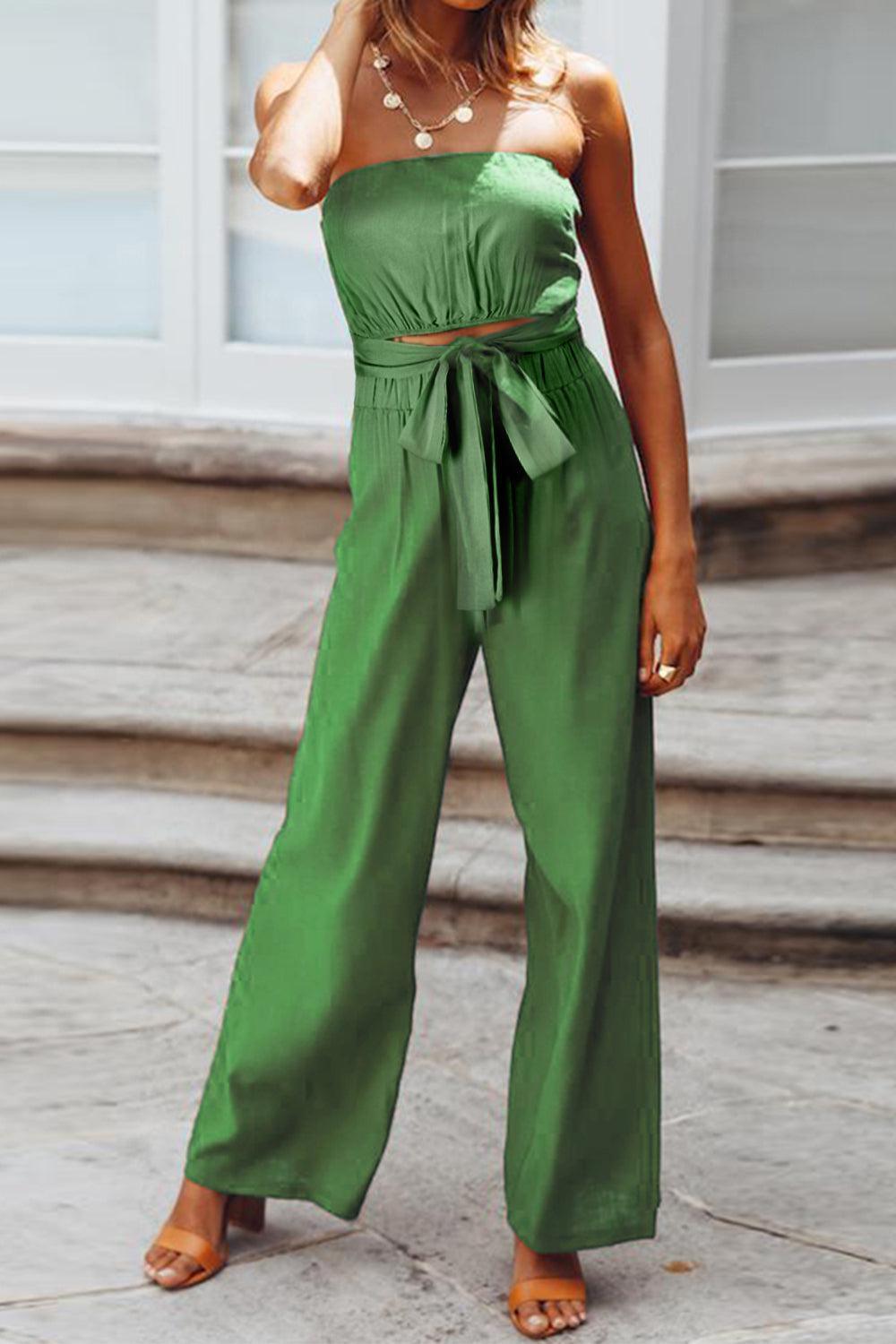 a woman wearing a green strapless jumpsuit