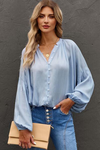 a woman wearing a blue blouse and jeans