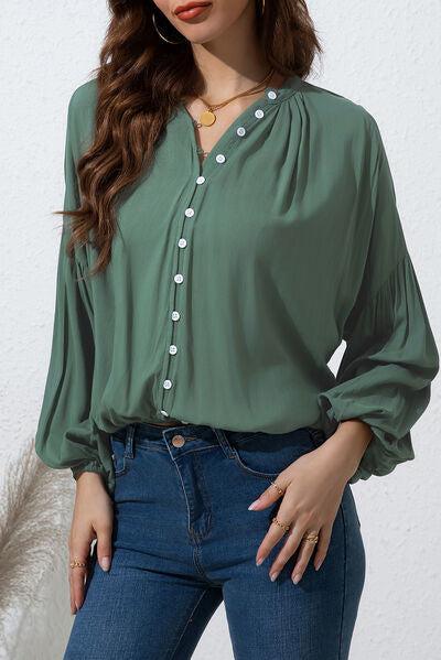 a woman wearing a green blouse and jeans