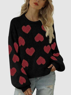 a woman wearing a black sweater with red hearts on it