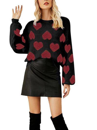 a woman wearing a black and red sweater with hearts on it