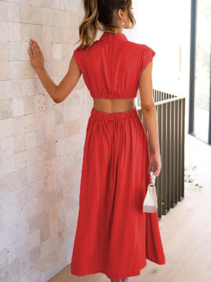 a woman in a red dress looking at a wall