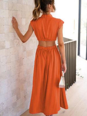 a woman in an orange dress looking at a wall