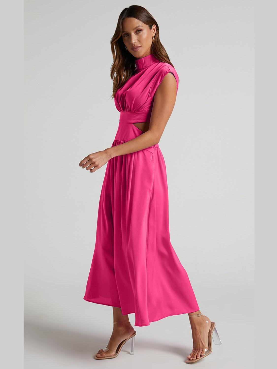 a woman in a pink dress poses for a picture
