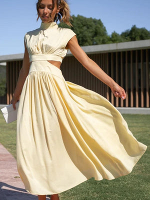 a woman in a yellow dress is walking in the grass