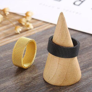 a wooden cone ring next to a black and gold ring