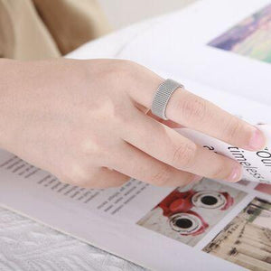 a woman's hand is holding a pen and a magazine