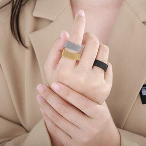 a woman in a trench coat holding a ring