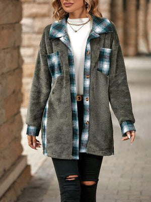 a woman walking down a sidewalk wearing a coat