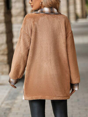 a woman walking down a street wearing a brown coat