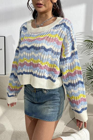 a woman wearing a colorful sweater and denim skirt