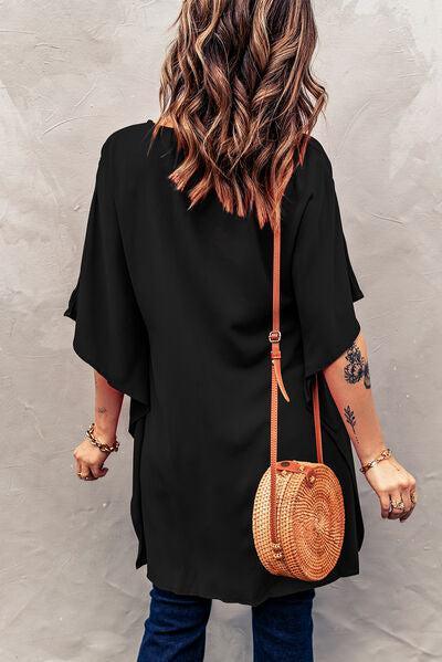 a woman wearing a black top and a straw bag