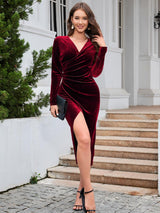 a woman wearing a red velvet dress with a thigh high slit