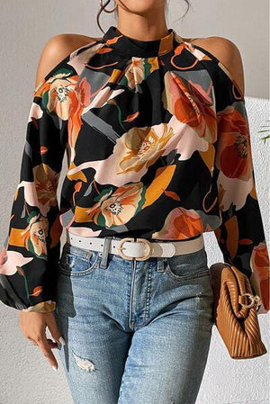 a woman wearing a floral blouse and jeans