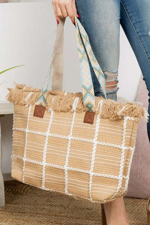 a woman is holding a woven bag