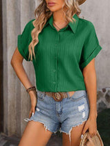 a woman wearing a green shirt and denim shorts