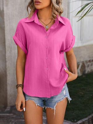 a woman wearing a pink shirt and denim shorts