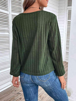 a woman wearing a green sweater and jeans