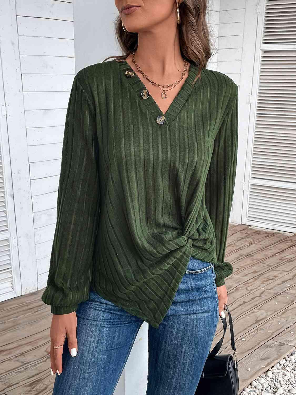 a woman wearing a green top and jeans