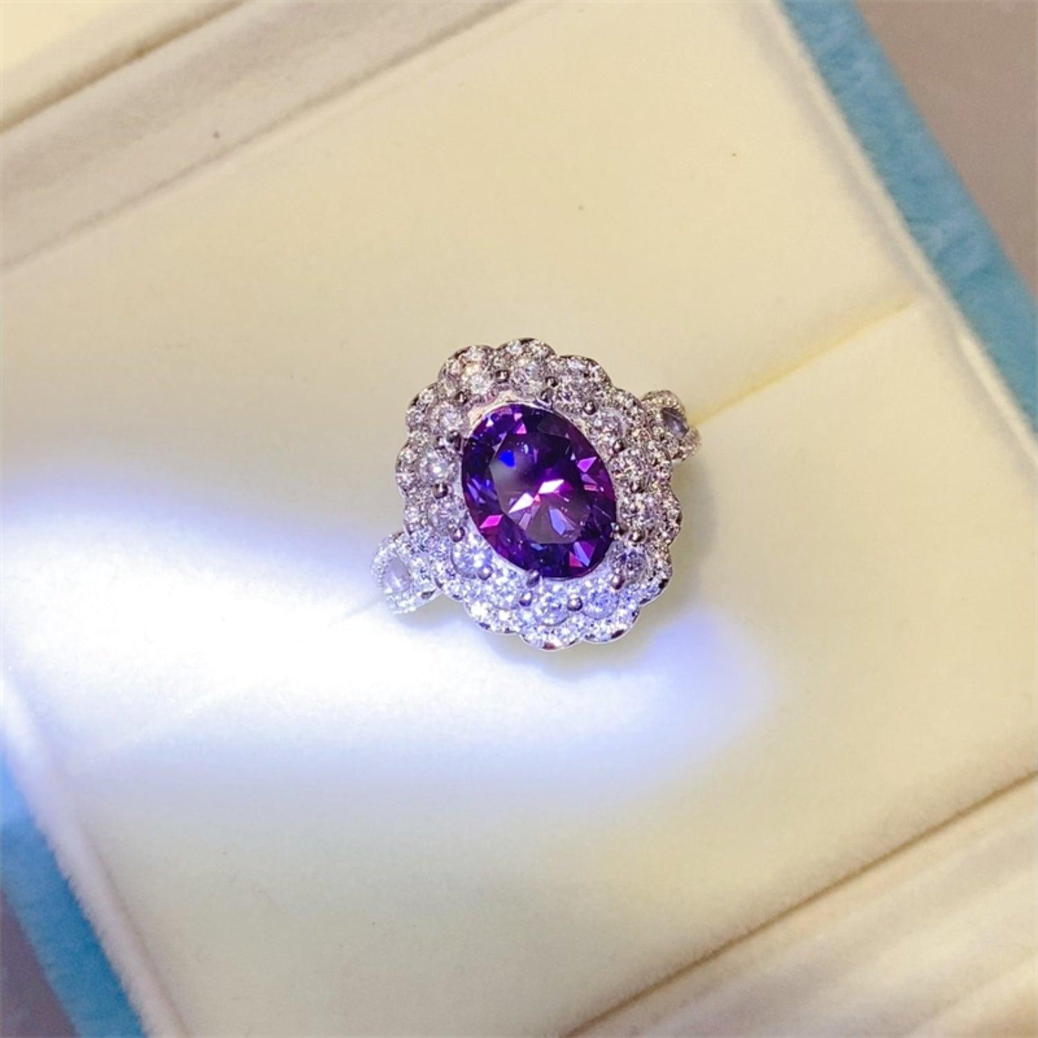 a ring with a purple stone surrounded by diamonds