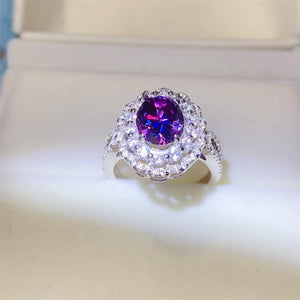 a ring with a purple stone surrounded by white diamonds
