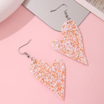 a pair of orange and white glitter heart shaped earrings