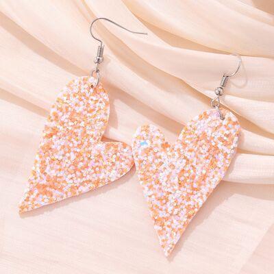 a pair of pink and orange glitter heart shaped earrings